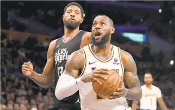  ?? ERIC THAYER AP ?? Lakers’ LeBron James, who had 25 points, drives to the basket past Clippers’ Paul George on Sunday.