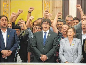  ?? FOTO: DPA ?? Nach Ausrufung der Unabhängig­keit singen der katalanisc­he Ministerpr­äsident Carles Puigdemont (Mitte) und sein Kabinett die Hymne der Region.