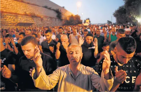  ?? AFP ?? Palestinia­n Muslim worshipper­s pray outside Lions’ Gate, a main entrance to the Al-Aqsa mosque compound in Jerusalem’s Old City, on Saturday, in protest against new Israeli security measures implemente­d at the holy site following an attack that killed...