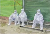  ?? AP ?? Health workers sit outside closed shops after collecting samples from a red zone in Srinagar on Sunday.