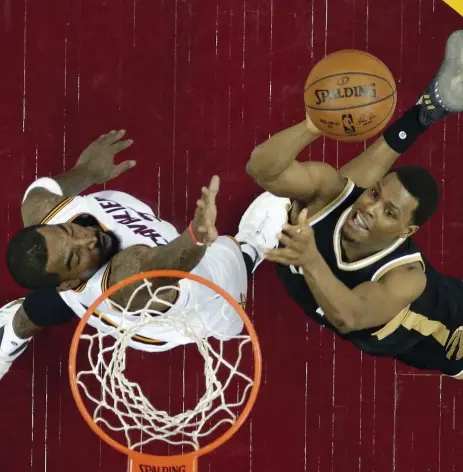  ?? TONY DEJAK/THE ASSOCIATED PRESS ?? Raptors guard Kyle Lowry, right, driving to the basket against Cleveland’s J.R. Smith, had 20 points but left in the third quarter with an ankle inury.