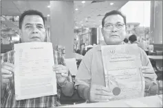  ??  ?? Entili (left) shows the police report while Pengiran shows the certificat­e for the associatio­n’s Tagang system at pungai Pang in rlu Ngemah.