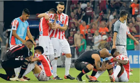  ?? FOTOS HANSEL VáSQUEZ, ENVIADO ESPECIAL ?? Dos jugadores del Atlético Paranaense consuelan a Luis Díaz y a Daniel Moreno, al final del partido en el estadio Arena da Baixada.