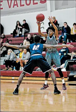  ??  ?? Calumet College’s Anthony Cole, right, passes over a Judson defender Dec. 1.
