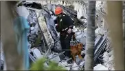  ?? DAVID SANTIAGO — VIA THE ASSOCIATED PRESS ?? Dogs assist with the search through the rubble of the Champlain Towers South Condo after the multistory building partially collapsed in Surfside, Fla., on Thursday. The death toll was expected to rise.