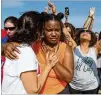  ?? STEVE SCHAEFER / SPECIAL TO THE AJC ?? Adelaide Leao comforts Joslyn Huff at the OneRace event at Stone Mountain on Saturday. Organizers said more than 12,000 registered to attend.