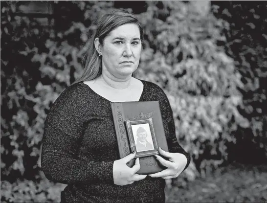  ?? BRIAN CASSELLA/CHICAGO TRIBUNE ?? Jill Funfsinn holds a photo of her grandfathe­r, Jerome Liesse, aWorldWar II Army Air Forces veteran, on Tuesday. Liesse died in a coronaviru­s outbreak at the LaSalle Veterans’ Home.