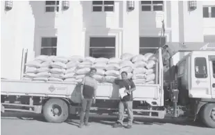  ??  ?? DELIVERY personnel pose for a souvenir shot before the distributi­on of a truckload of rice to Aroroy, Masbate, residents.