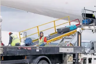  ?? PABLO MONGE ?? Operarios de WFS durante la operación de carga de maletas en un avión en el aeropuerto de Madrid-Barajas.