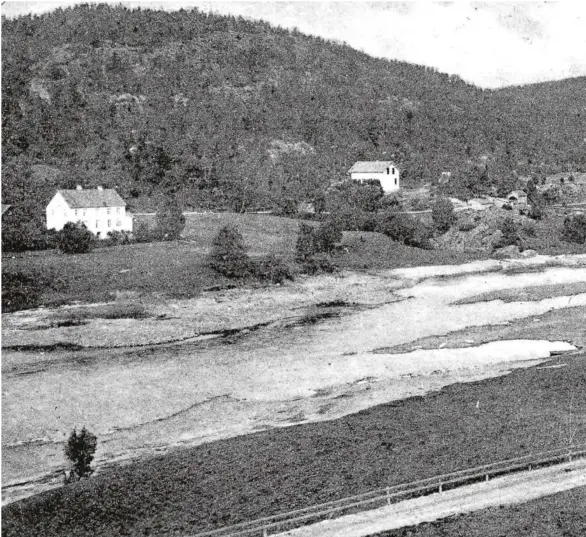  ??  ?? OVER 100 ÅR SIDEN: Froland kirke ligger like ved Nidelva. Jernbanen som nå går på bru like forbi kirken, ble åpnet i 1908 så dette bildet må vaere noen år eldre,skriver forfattern­e av boken Kjerka ved Nidelva. Prestegård­en ligger til venstre.