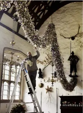  ??  ?? Dave Bouch oversees the installati­on of the garland, which weighs an impressive 120kg
OPPOSITE A number of local bands and choirs perform for visitors in the Great Hall at Christmas