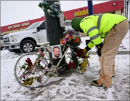  ?? PHOTOS BY HELEN H. RICHARDSON — THE DENVER POST ?? Eric Elliott brushes snow off of flowers and a photo of his brother-in-law and hit-and-run victim Logan Rocklin at the intersecti­on of Sheridan Boulevard and West 38th Avenue in Denver on Sunday.