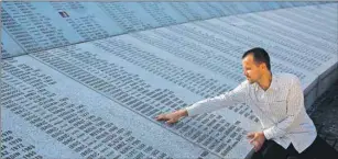  ?? AP FILE PHOTO ?? Srebrenica massacre survivor Nedzad Avdic , 37, touches the engraved names of those killed in the 1995 massacre.