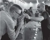  ?? AP Photo ?? Kyle Bell of Numo Cannabis helps a customer decide on his purchase of legal marijuana.