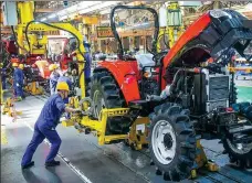  ?? ZHANG YIXI / FOR CHINA DAILY ?? Employees work on the production line of a tractor manufactur­er in Luoyang, Henan province.