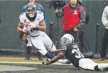  ??  ?? Broncos wide receiver Cody Latimer, scoring against Oakland Raiders cornerback T.J. Carrie this season, is dealing with a “really sore” thigh, coach Vance Joseph said.