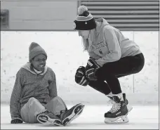  ??  ?? Tether Preston, a member of the Connecticu­t College recreation women’s hockey team, talks with Adrian Escobosa, a Bennie Dover Jackson Middle School eighth-grader, after he fell during the Learn to Skate program.