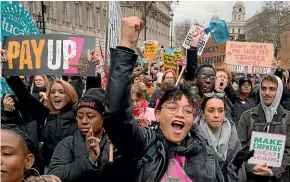  ?? AP ?? Demonstrat­ors wave banners as they stand in Westminste­r at the heart of the British Government in London.