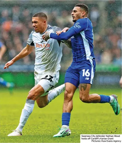  ?? ?? Swansea City defender Nathan Wood holds off Cardiff’s Karlan Grant
Pictures: Huw Evans Agency