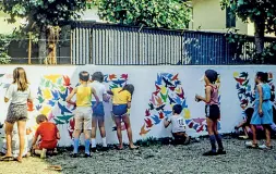  ??  ?? Ieri e oggi Sopra i ragazzi negli anni ‘70 mentre realizzano un murale dedicato alla pace. Sotto Claudia Sereni con Tiziano Bonanni e Skim davanti al nuovo murale