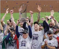  ?? KEVIN M. COX / THE GALVESTON COUNTY DAILY NEWS VIA AP ?? Braves manager Brian Snitker hoists the trophy as first baseman Freddie Freeman cheers after the Braves won the World Series with a win over the Astros in Game 6 of the series on Tuesday in Houston.