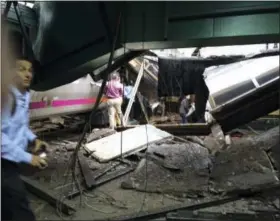  ?? THE ASSOCIATED PRESS ?? In a photo provided by William Sun, people examine the wreckage of a New Jersey Transit commuter train that crashed into the train station during the morning rush hour in Hoboken,, N.J., Thursday, Sept. 29, 2016.