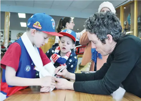  ??  ?? Western Bulldogs legend and former Warragul junior Robert Murphy was at the Gulls’ match on Saturday signing copies of his book “Leather Soul” with young Bulldogs fan Liam Phillips also getting an autograph on the plaster of a broken arm as brother Milla takes a close interest.The popular Murphy gave further insights when he addressed the annual luncheon in the clubrooms of the Gulls’ fund-raising group, the “Cattlemen’s Club”.