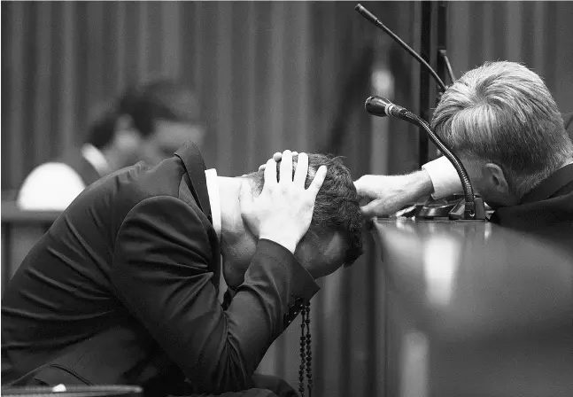  ?? Marco Longari / The Associate d Pres ?? Oscar Pistorius hides his head Thursday while listening to evidence from a witness about the morning of the shooting of girlfriend Reeva Steenkamp.