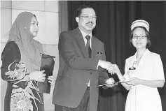  ??  ?? Zuki (centre) presents an award to a recipient while Dr Jamilah (left) looks on. — Photos by Chimon Upon