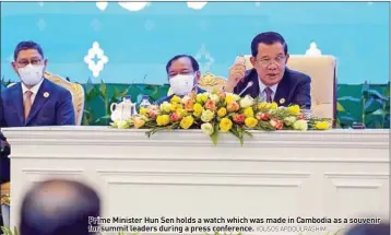  ?? YOUSOS APDOULRASH­IM ?? Prime Minister Hun Sen holds a watch which was made in Cambodia as a souvenir for summit leaders during a press conference.