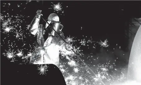  ?? REUTERS ?? An employee controls the tapping of a blast furnace at Germany's industrial conglomera­te ThyssenKru­pp AG, Europe's largest steel factory, in the German city of Duisburg.