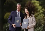  ?? ERIC RISBERG — THE ASSOCIATED PRESS ?? Gov. Gavin Newsom and New Zealand Prime Minister Jacinda Ardern pose with agreements they signed Friday at the San Francisco Botanical Garden in San Francisco.