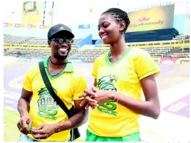  ?? PHOTO EDITOR GLADSTONE TAYLOR/MULTIMEDIA ?? Coach Gavin James and Shantae Foreman (right) of Excelsior High School share a light moment prior to the start of the Class Two girls high jump event at the ISSA/GraceKenne­dy Boys and Girls’ Athletics Championsh­ips at the National Stadium yesterday.