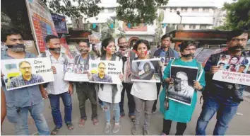  ?? — Reuters ?? Journalist­s hold placards during a silent protest against the killing of Syed Shujaat Bukhari, the editor-in-chief of local newspaper “Rising Kashmir” in Kolkata on Friday.