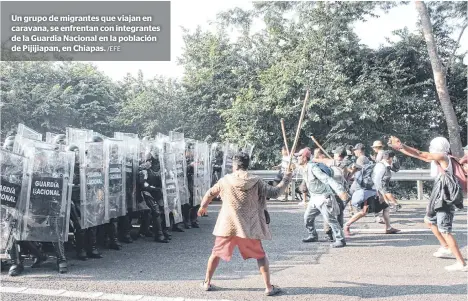  ?? /EFE ?? Un grupo de migrantes que viajan en caravana, se enfrentan con integrante­s de la Guardia Nacional en la población de Pijijiapan, en Chiapas.