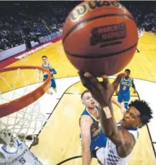  ??  ?? Kentucky frosh De’Aaron Fox drives to the basket against UCLA’s Bryce Alford on Friday. Fox scored 39 points. Andy Lyons, Getty Images