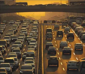  ?? Mark Schiefelbe­in Associated Press ?? A REPORT by the United Nations Environmen­t Program shows that greenhouse gas emissions hit a new high last year despite near-universal pledges to reduce them. Above, Beijing drivers endure rush-hour traffic.