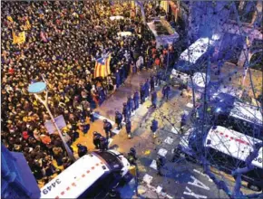  ?? NICHOLAS KAMM/AFP ?? Protesters stand opposite riot police blocking the road leading to the central government offices during a demonstrat­ion in Barcelona on Sunday.