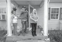  ?? Associated Press ?? n In this Dec. 9, 2016, photo, Zaine Pulliam, center, stands by family friend Jewels Hudson, left, and his grandmothe­r Madie Clark at his family home in South Charleston, W.Va. Zaine and his two sisters lost their parents to heroin overdoses. The...