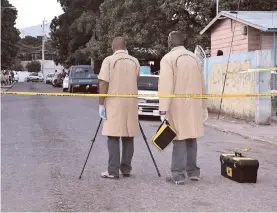  ??  ?? Scene of Crime detectives conduct investigat­ions at the scene of a triple murder.