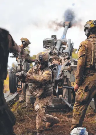  ?? ?? Australian Army soldier Gunner Zach Campbell from the 4th Regiment, Royal Australian Artillery, fires the M777 155mm howitzer during Exercise Chau Pha; (below) a soldier prepares to load a shell. Main picture: Corporal Dustin Anderson