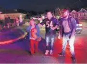  ?? CHRIS YUCUS/NEWSTRIBUN­E ?? Jeremy Gossett, right, and Mathew McBee, center, help escort a woman and her dog to a firetruck following a tornado in Naplate, Ill., late Tuesday night.