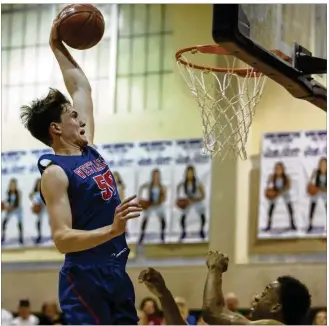  ?? STEPHEN SPILLMAN / FOR AMERICAN-STATESMAN ?? Westlake’s Will Baker (50) dunks over Wagner’s Justice Tolbert (14) during 6A regional quarterfin­als last month at San Marcos High School.