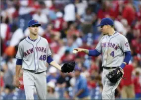  ?? MICHAEL PEREZ — THE ASSOCIATED PRESS ?? The New York Mets’ Wilmer Flores (4) hands the game ball to Jacob deGrom (48) at the end of the ninth inning against the Philadelph­ia Phillies, Saturday in Philadelph­ia. The Mets won 3-1.