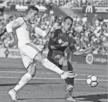  ?? (AP PHOTO/PAUL WHITE) ?? REAL Madrid's Cristiano Ronaldo, left, shoots to score the winning goal during a Spanish La Liga soccer match between Getafe and Real Madrid at the Coliseum Alfonso Perez in Getafe, Spain, Saturday, Oct. 14, 2017.