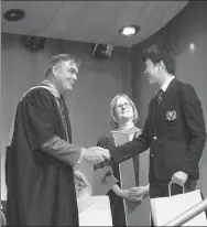  ?? PROVIDED TO CHINA DAILY ?? Sam McKinney (left), principal of Upper Canada College, shakes hands with Chinese boarder Liu Weiyi (right) at his graduation ceremony.