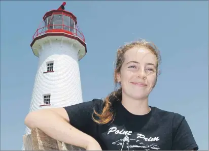  ?? HEATHER TAWEEL/THE GUARDIAN ?? Tour guide Sara MacRae sits in front of the Point Prim Lighthouse, which is expected to be divested to a volunteer community group by November. The group, called the Point Prim Lighthouse Society, has many projects planned to upgrade the popular tourist spot.