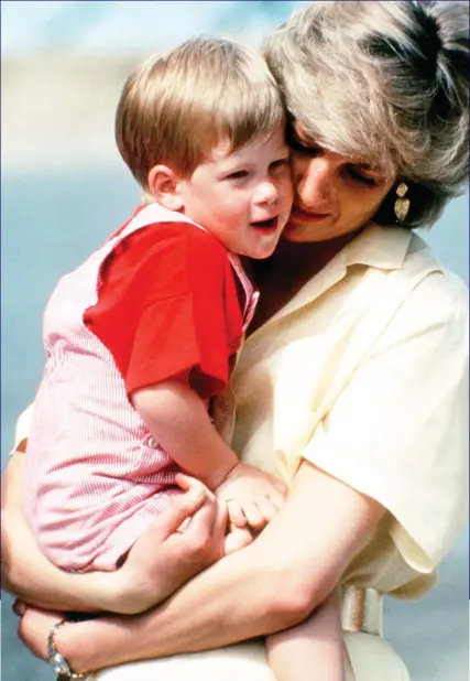 ??  ?? That’s my boy: Harry is cuddled in his mother Diana’s loving arms shortly before his third birthday