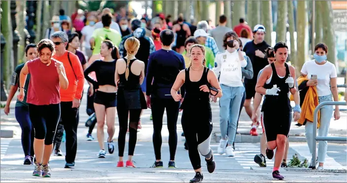  ??  ?? RUNNING FREE: Joggers in the Spanish city of Barcelona yesterday enjoy the easing of lockdown restrictio­ns that allows people to leave their homes in time slots allocated to different age groups