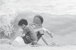  ?? — Gambar Bernama ?? MENGUNDANG BAHAYA: Dua kanak-kanak ini bermain di tepi Pantai Bersih, Bagan Ajam walaupun ombak kuat berikutan fenomena air pasang besar semalam.